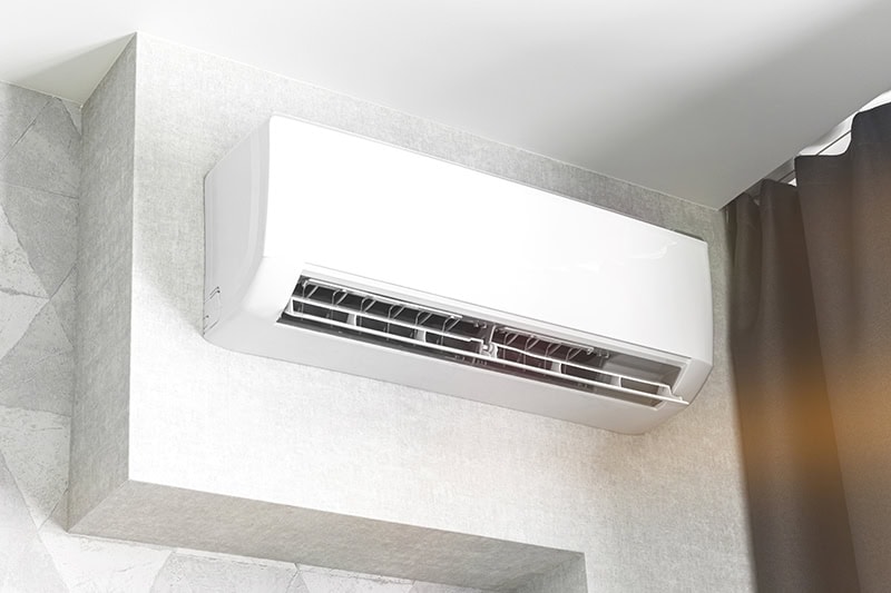 A white ductless unit on a white wall.