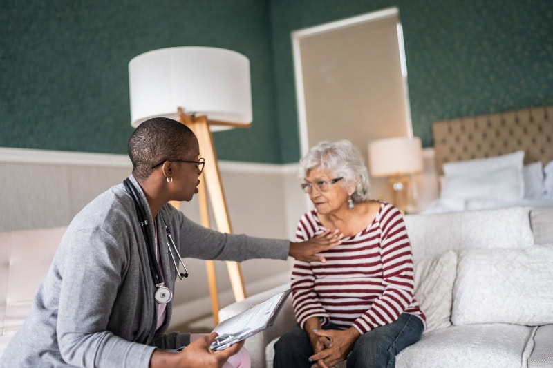Doctor talking to a senior woman in the bedroom.